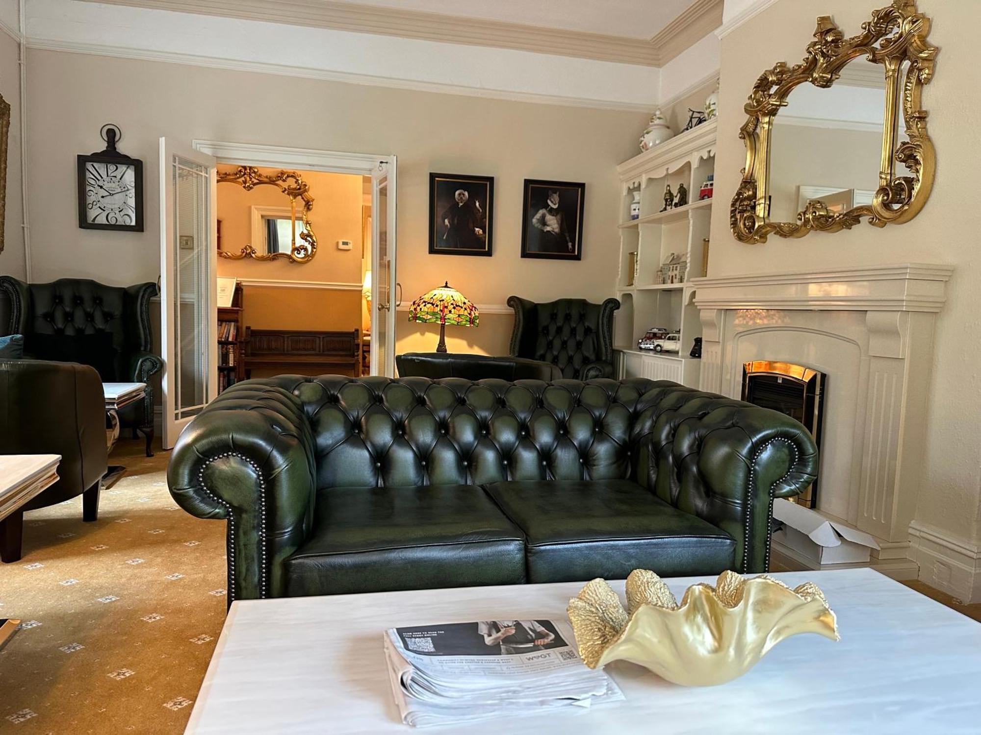Chester House Guest House Екстериор снимка A green leather Chesterfield sofa